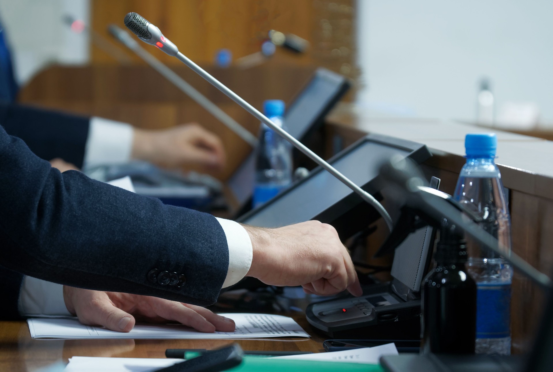 The politician's hand is extended to the voting device. The concept of making a decision and adopting amendments to legislation. Selective focusing